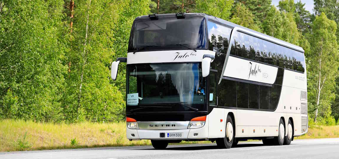 Autocar à impériale (double étage) de grande capacité circulant sur une route forestière, une alternative à l'autocar 75 places pour les groupes plus importants