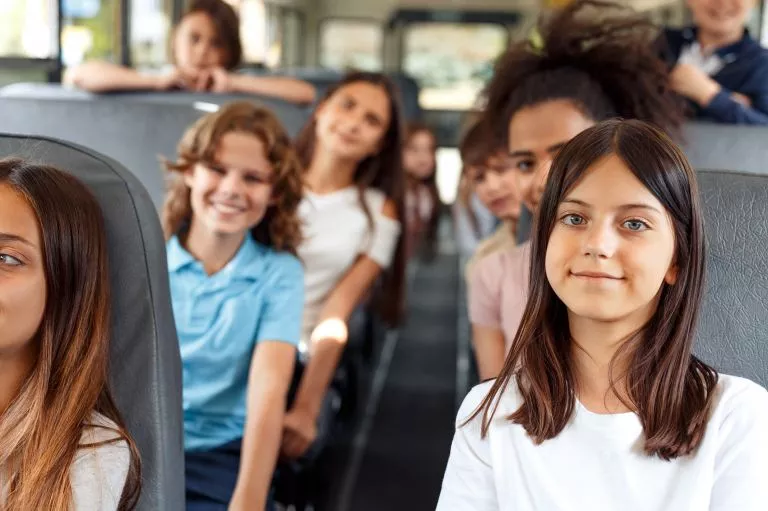 Élèves assis à bord d'un bus scolaire pendant le trajet, ceinture de sécurité attachée