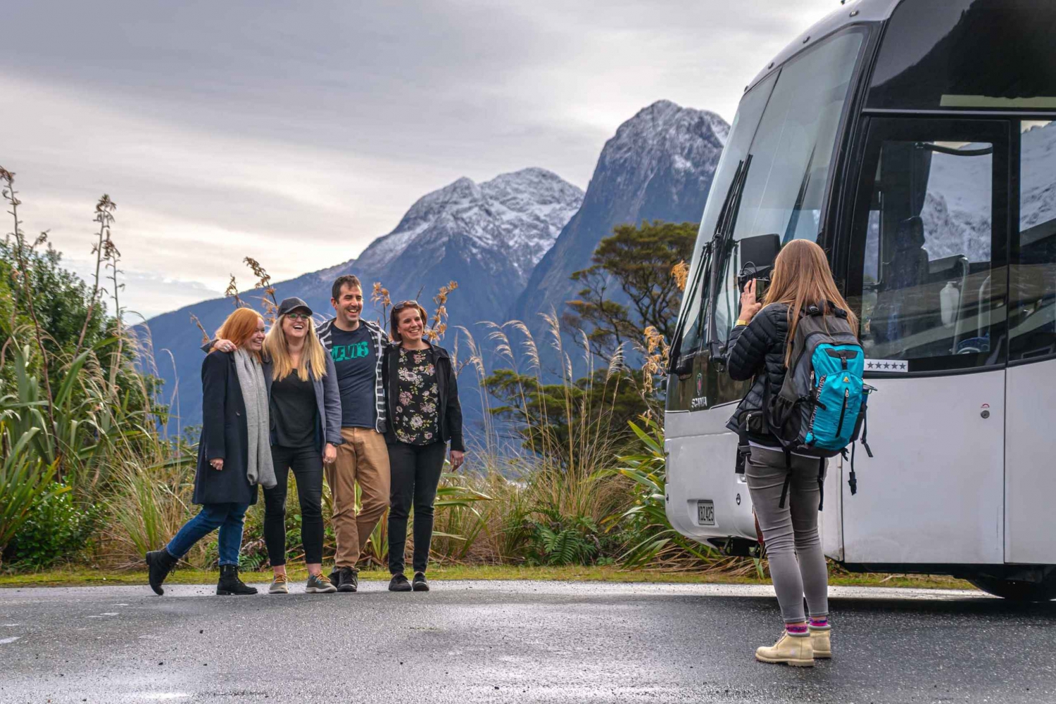 Groupe d'amis prenant une photo souvenir devant leur autocar lors d'une excursion à la journée en montagne