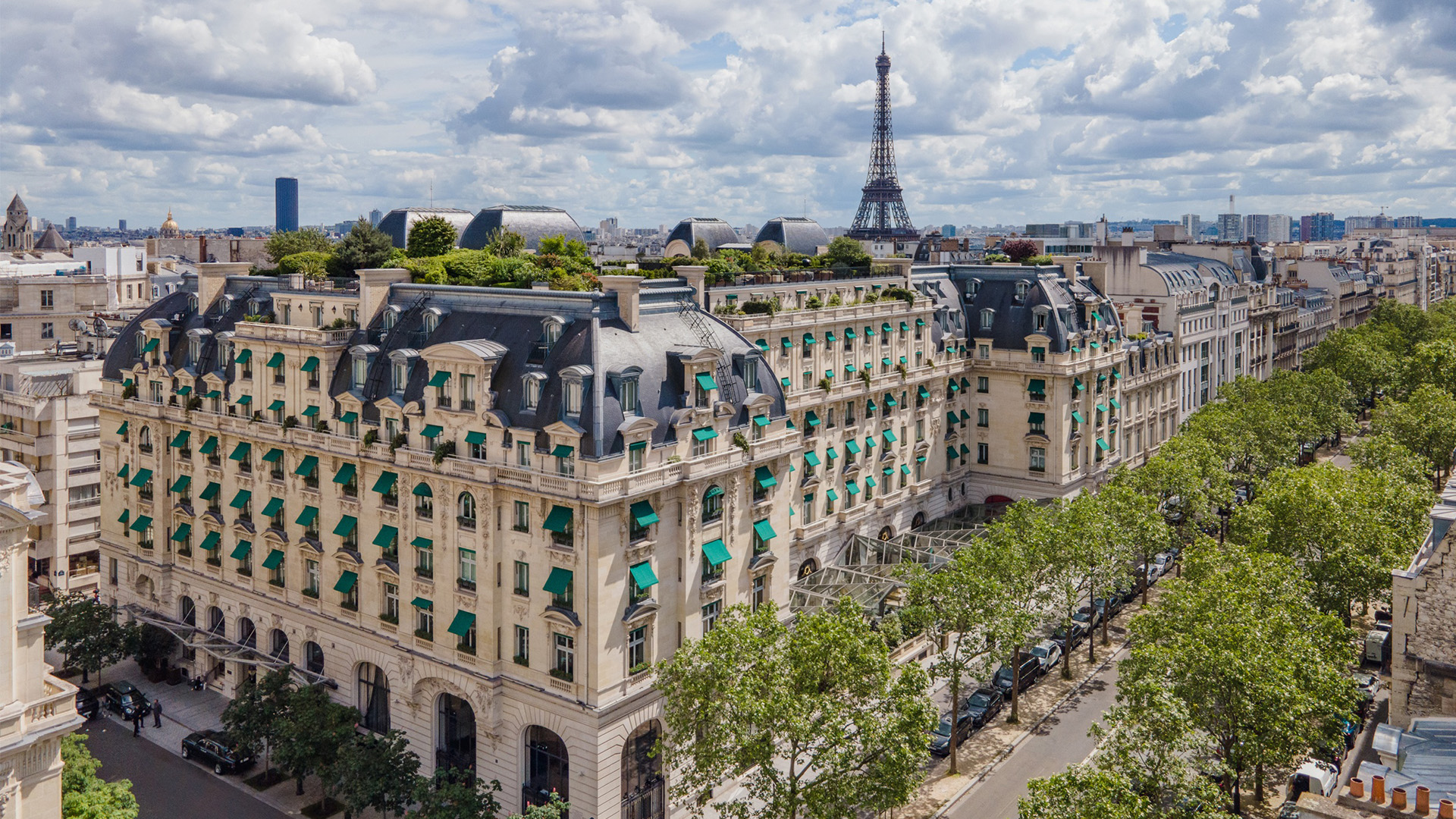 Vue sur les toits de Paris et la Tour Eiffel depuis un immeuble haussmannien, quartier desservi par nos minibus